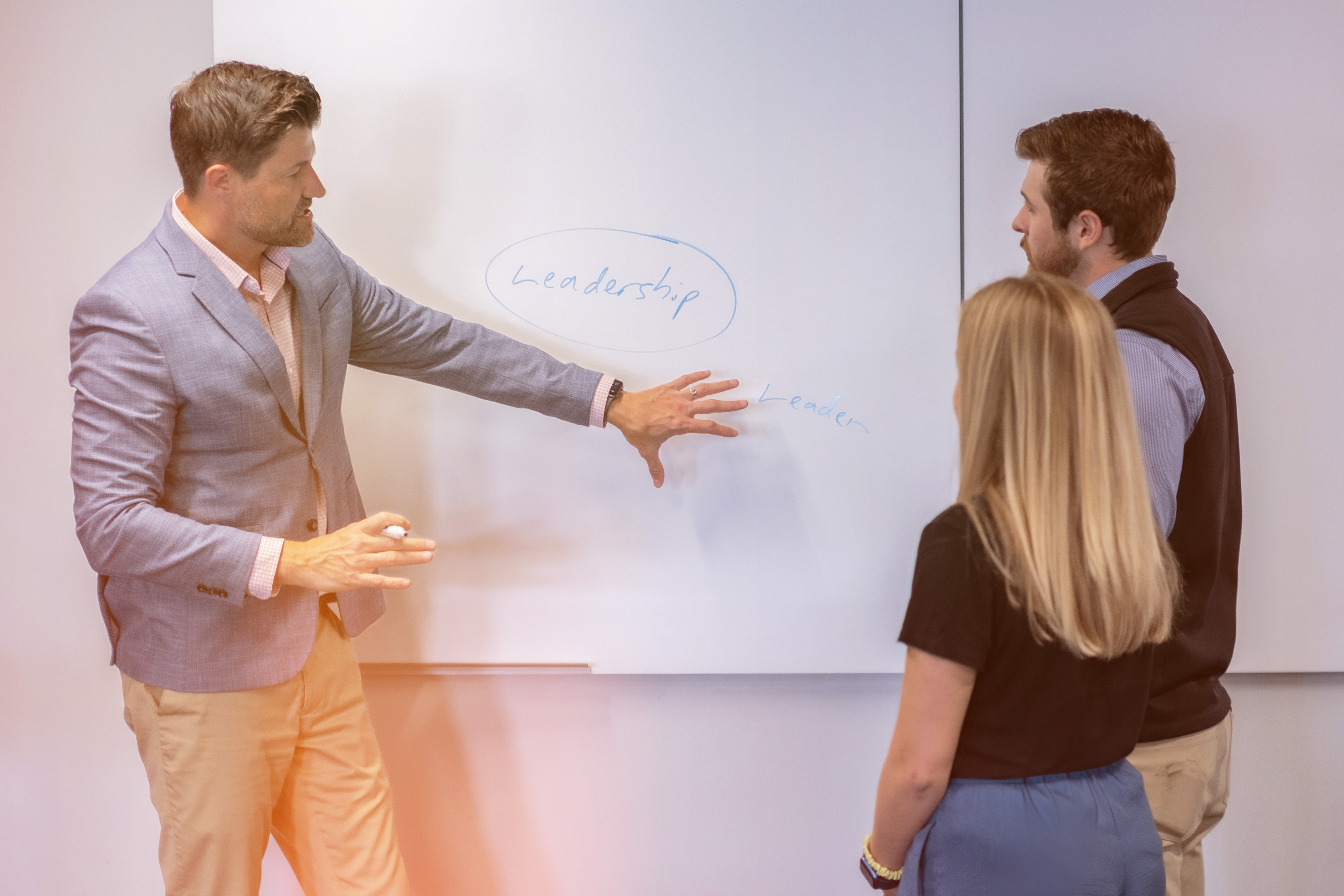 Group of Employees Gathered around Whiteboard