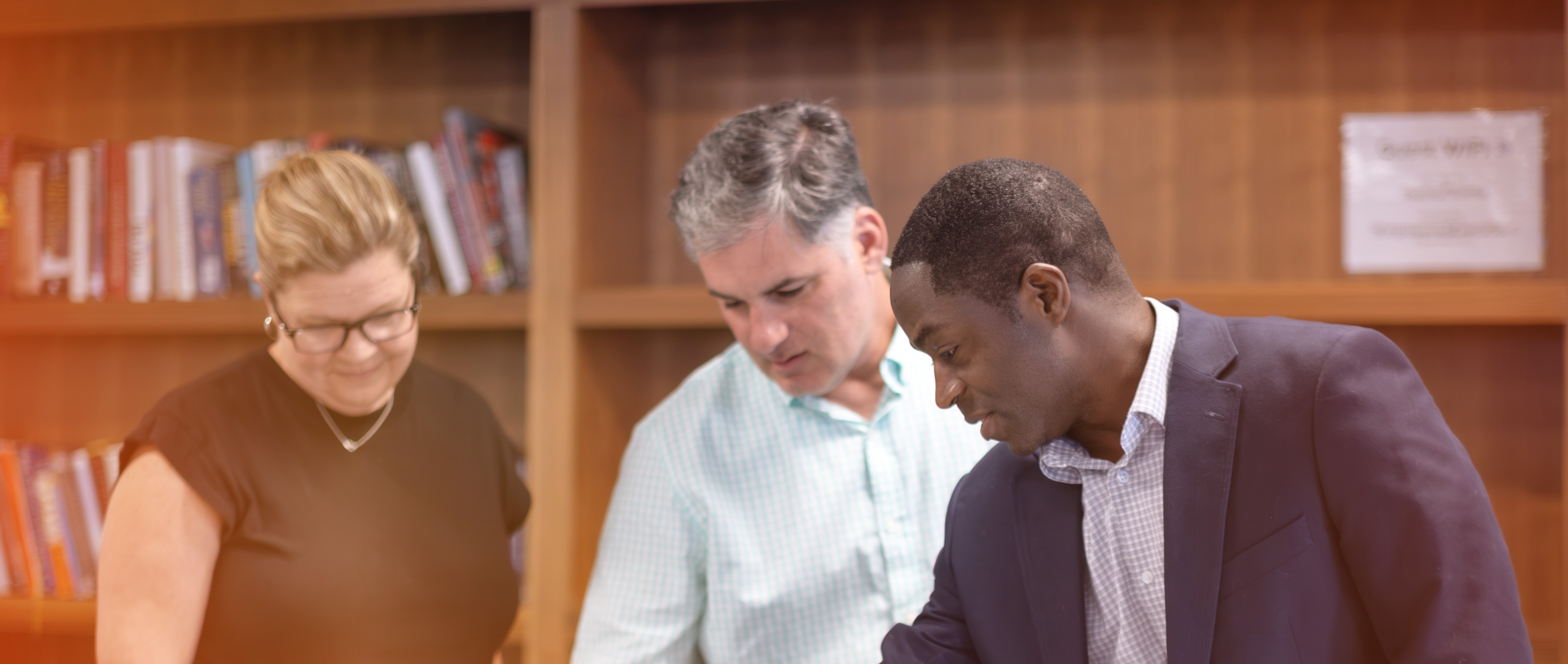 Three Employees Discussing Work on a Computer Screen